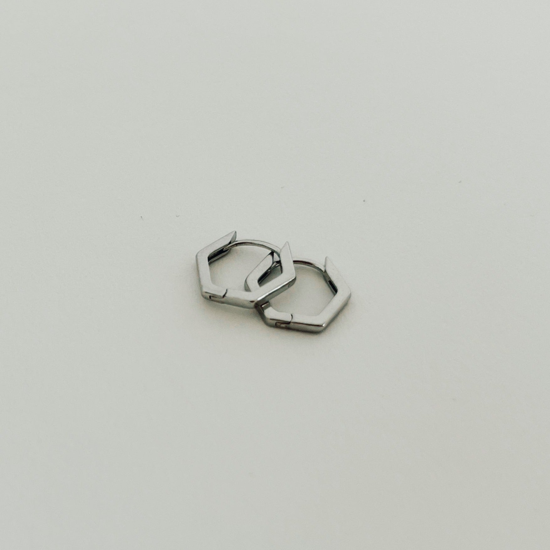 Silver hexagon huggies.
