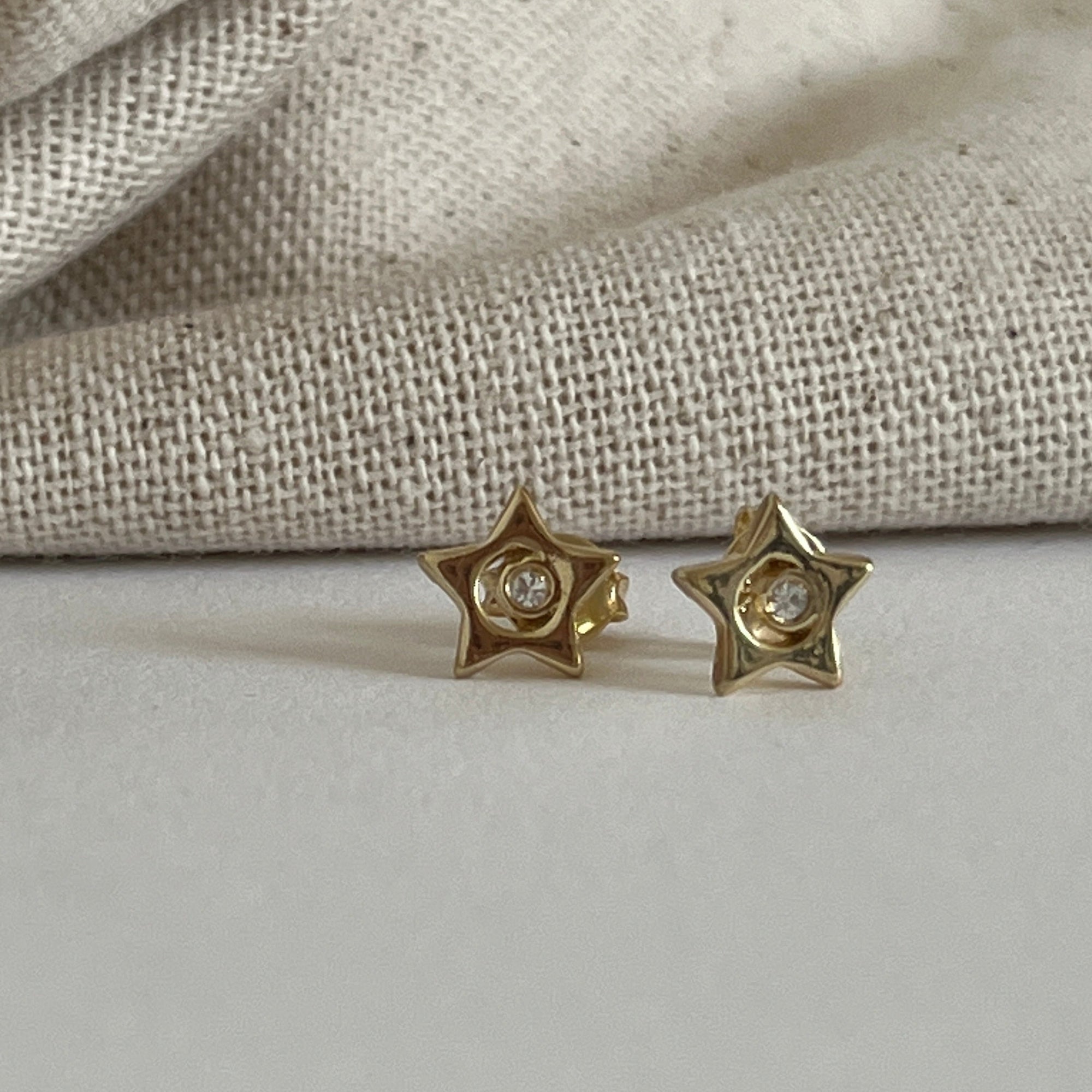 gold filled star studs with sparkle in middle.