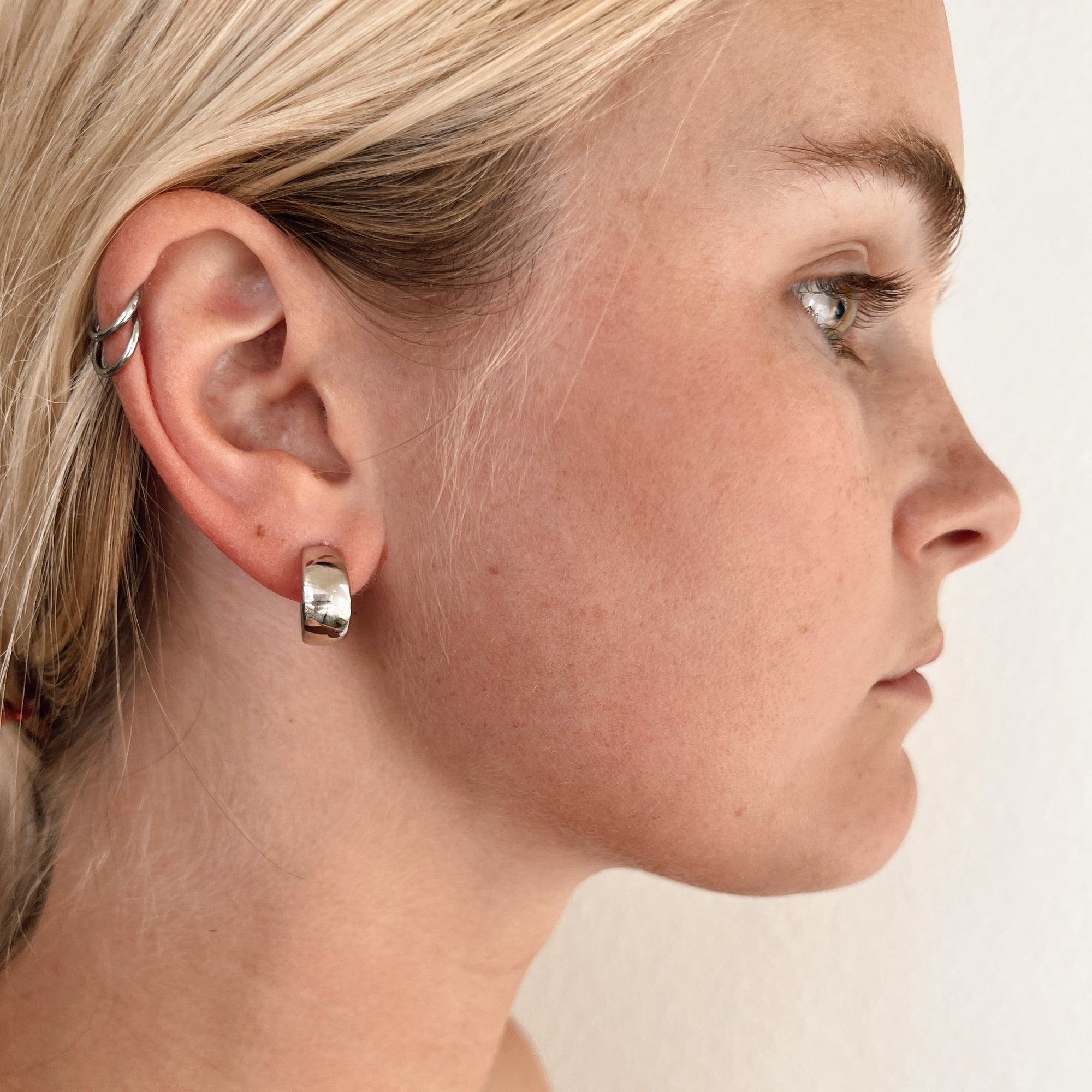 silver lemmie earring on ear. 