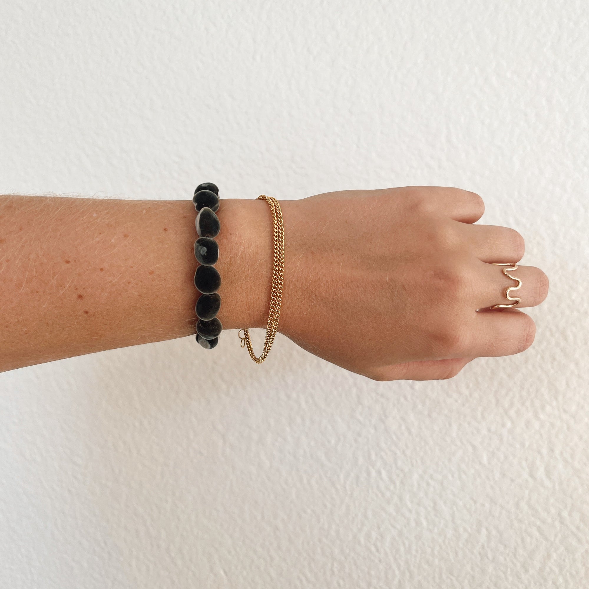 koa mgambo seed bracelet on model with gold bracelet. 