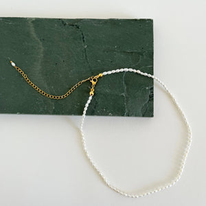 Ruth Pearl Choker necklace on green rock. 