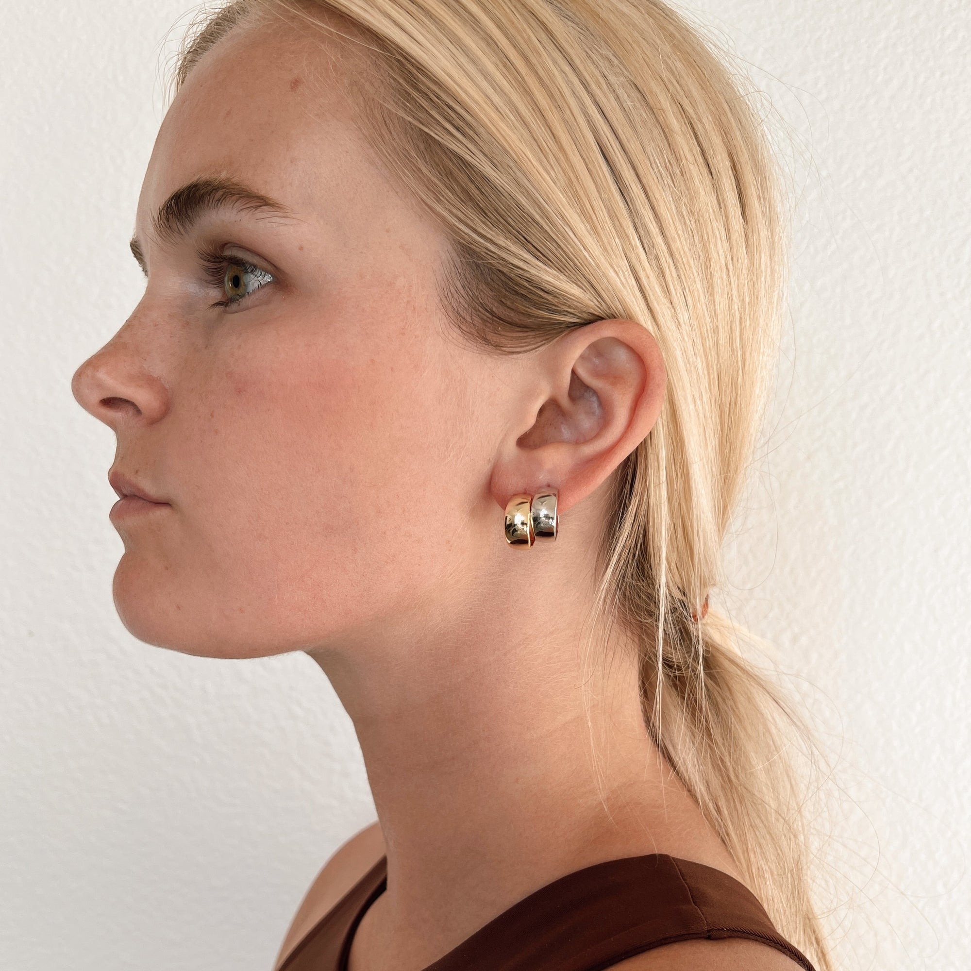 gold and silver wide hoop earring on model.